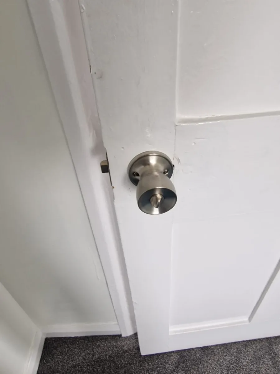 Brushed steel tubular knob and latch fitted to a white internal door